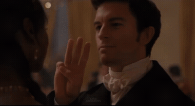 Woman With Tiara Looks At Man In Suit GIF