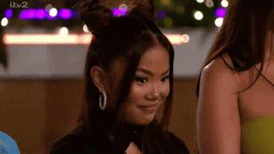 Woman With Two Buns Smiling Next To Another GIF