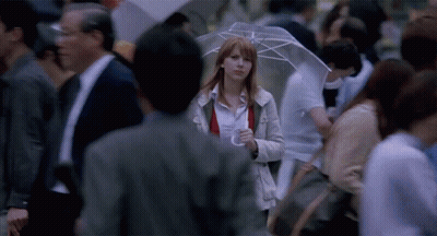 Woman With Umbrella Walking Through Crowd GIF