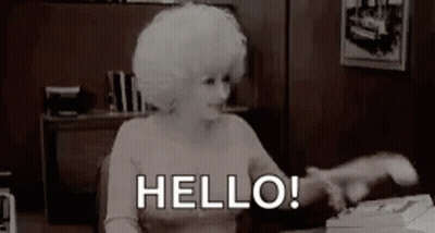 Woman With White Hair Sitting At Typewriter Saying Hello GIF