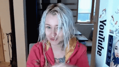 Woman With White Hair Sitting In Front Of YouTube Sign GIF