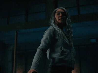 Woman With White Hair Standing Eyes Closed In Dark Room GIF