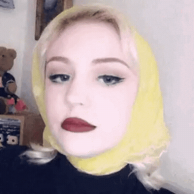 Woman With Yellow Scarf And Red Lipstick Making Funny Face GIF