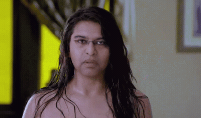 Woman Without Shirt Looking At Camera Yellow Wall GIF