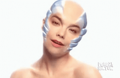 Woman Without Shirt Wearing Robot Mask GIF