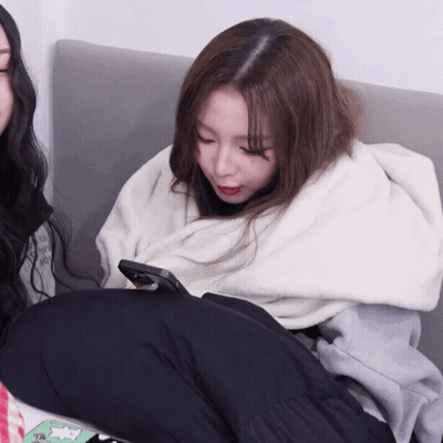 Woman Wrapped In White Blanket Looking At Phone GIF
