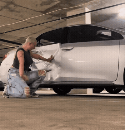 Woman Wrapping Silver Car In Plastic GIF