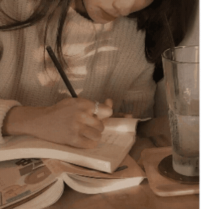 Woman Writing In Notebook At Table GIF