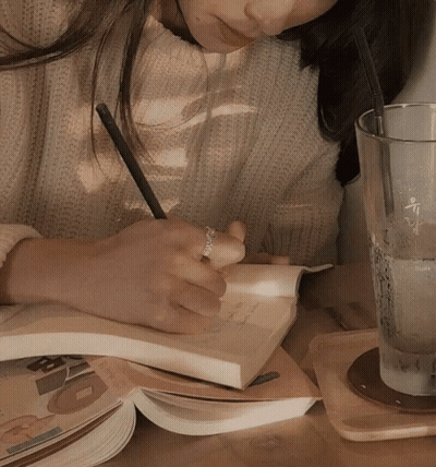 Woman Writing In Notebook Next To Water Glass GIF