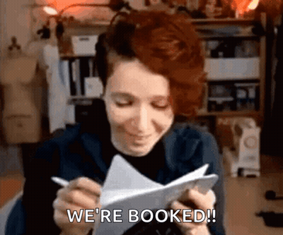 Woman Writing We're Booked GIF