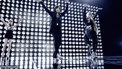 Women Dancing In Front Of Wall Of Lights GIF