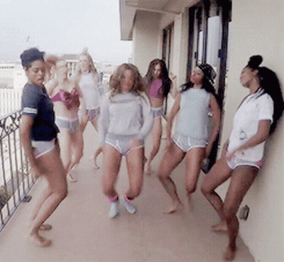 Women Dancing on Balcony With Shirt Saying A