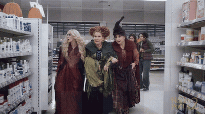 Women Dressed As Witches Walk Through Pharmacy GIF