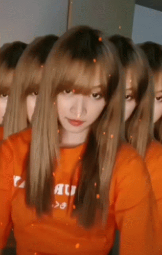 Women in Orange Shirts Looking at Camera
