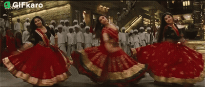 Women In Red And Gold Dresses Dancing With Gifkaro Logo GIF