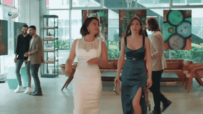 Women In White And Blue Dresses Walking Through Art Gallery GIF