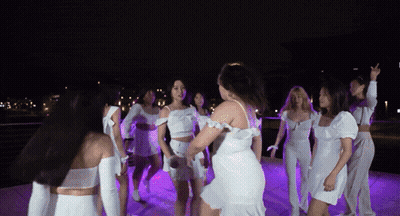 Women In White Dresses Dancing In Circle At Night GIF