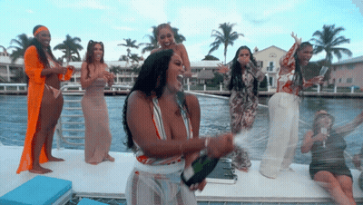 Women On Boat Holding Champagne Bottles GIF