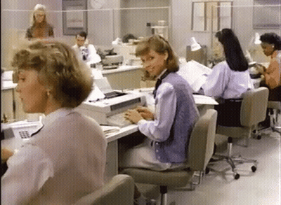 Women Sitting At Desks In Office With Printer GIF
