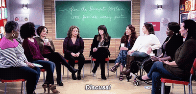 Women Sitting In Circle In Front Of Chalkboard Saying Discuss GIF