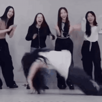 Women Standing Around Man Doing Handstand GIF