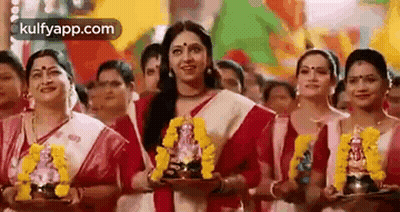 Women Standing Holding Ganesha Statue GIF