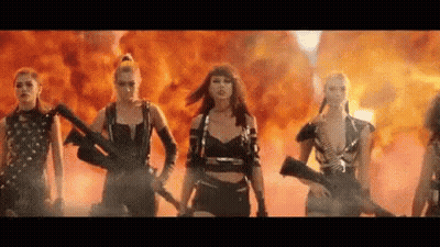 Women Standing In Front Of Fire Holding Guns GIF
