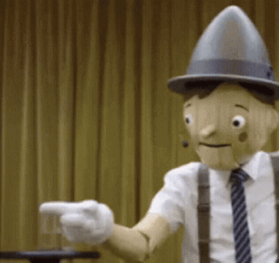 Wooden Puppet In Hat And Suspenders Pointing GIF