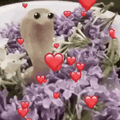 Worm Sitting On Plate Of Purple Flowers With Red Hearts GIF