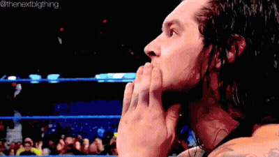Wrestler Covering Mouth In Ring With Crowd GIF