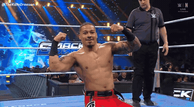 Wrestler Flexing Muscles In Ring With Referee GIF