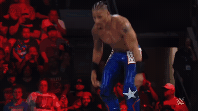 Wrestler Flexing Muscles In Ring With Referee GIF