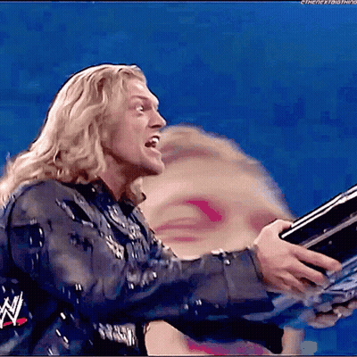 Wrestler Holding Trophy in Front of Blurry Woman Face