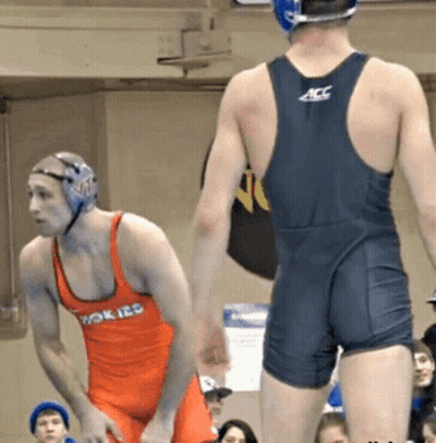 Wrestler In ACC Uniform Next To Wrestler In Orange Tank Top GIF