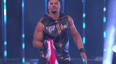 Wrestler In Black And Gold Holding Flag GIF
