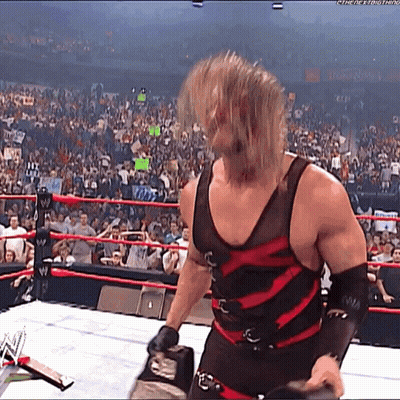 Wrestler In Black And Red Outfit In Ring With Crowd GIF