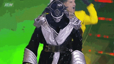 Wrestler In Black And Silver Walking With Yellow Jacket Man GIF