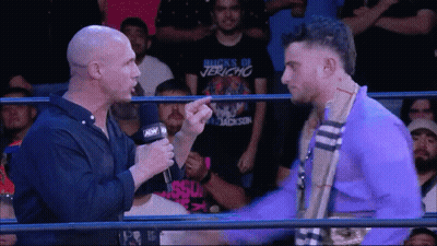Wrestler In Buck's Of Jericho Shirt Talking To Another Wrestler GIF