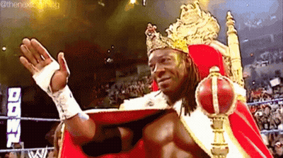 Wrestler In Crown And Red Cape On Throne GIF