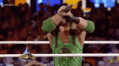 Wrestler In Green Tank Top Holding Microphone In Ring GIF