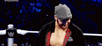 Wrestler In Hat And Plaid Shirt Covering Mouth GIF
