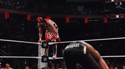 Wrestler In Red And White Outfit Jumping Over Ropes GIF
