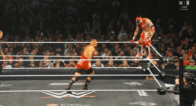 Wrestler In Red Outfit Jumping Over Ropes GIF
