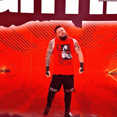 Wrestler In Red Tank Top And Black Shorts On Red Stage GIF