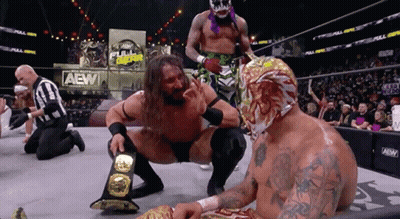 Wrestler Kneeling Next To Another In AEW Ring GIF