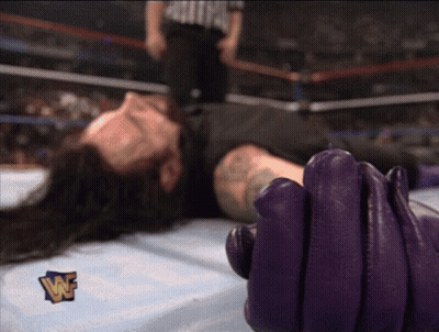 Wrestler Laying On Ground With Purple Glove And W Logo GIF