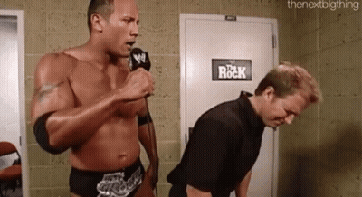 Wrestler Speaking Into Mic Next To Another Wrestler GIF