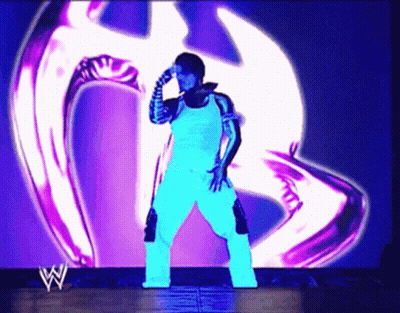 Wrestler Standing In Front Of Purple Logo GIF