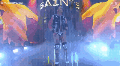 Wrestler Standing In Front Of Saints Sign GIF