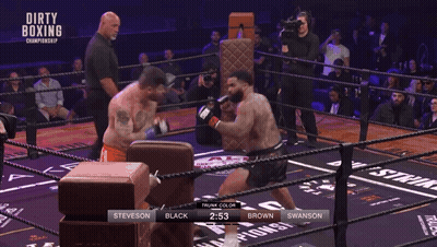 Wrestler Stretching Arms In Front Of Olympic Logo GIF
